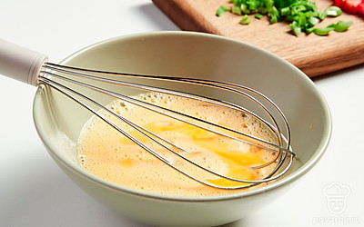 Подготовьте начинку. Натрите на крупной терке сыр. Помидоры порежьте кубиками. Мелко нашинкуйте лук. Разбейте в миску яйца и взбейте.