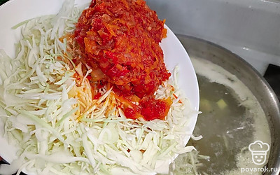 Капусту нашинковать.Затем капусту с замороженной зажаркой выложить в кастрюлю.