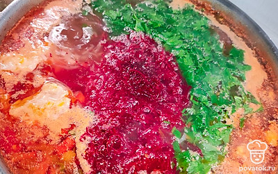 Приправить измельченной зеленью и отправить в бульон тертую свелку. При добавлении свеклы щи станут яркого цвета, но через 10 минут цвет щей становится ближе к томатному. После выложить тертый чеснок и выключить газ.