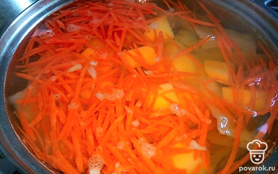 Через минут 5 добавьте картошку и морковь. Перемешайте, накройте крышкой.