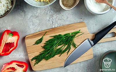 Приготовьте начинку и заливку. Вареные яйца нарежьте мелким кубиком, выложите их в миску, добавьте укроп, рис, сырое яйцо, перец и соль. Все тщательно перемешайте до однородности. В другой миске смешайте воду со сметаной.