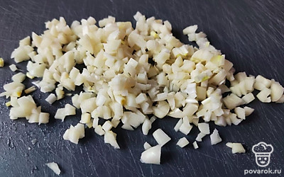 Мелко нарубите чеснок, отправьте в кастрюлю.