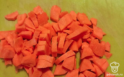 Пока рыба варится, чистим и режем морковь, затем высыпаем ее в бульон.