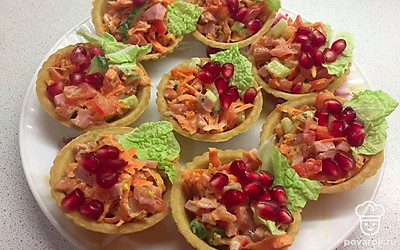 Подавайте тарталетки с морковью по-корейски сверху украсив листком салата и ягодами граната.