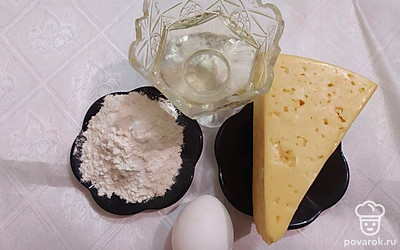 Твердый сыр заранее положите в холодильник или морозильную камеру на несколько минут, для того чтобы он затвердел. Приготовьте необходимое количество муки и просейте ее через мелкое сито. Яйцо достаньте из холодильника и разбейте в удобную для вас посуду.