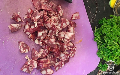 Приготовить копченую колбасу, мелко нарезать и добавить в суп.