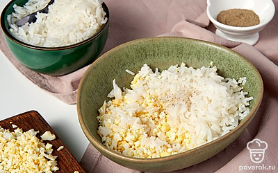 Подготовьте продукты для начинки. Залейте рис водой в отношении 2:3, доведите до кипения, подсолите и варите еще 10 минут. Слейте лишнюю жидкость и остудите. Яйца очистите от скорлупы и мелко нарежьте. Смешайте рис с яйцом, поперчите и посолите по вкусу.