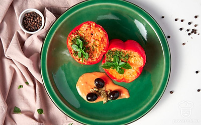 Готовые перцы теплыми переложите на блюдо, украшенное свежей зеленью.