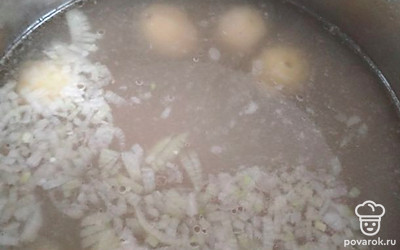 В кипящий бульон отправить лук, картошку и рис, варить до готовности риса.