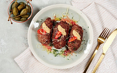 Мясо, фаршированное яйцом, выложите на тарелку для подачи. В качестве украшения используйте петрушку. Зелень измельчите и посыпьте ею блюдо.