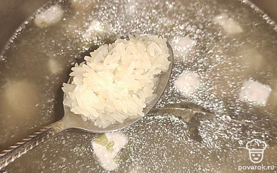 Добавьте в кастрюлю промытую рисовую крупу и лавровый лист. Варите суп на среднем огне.