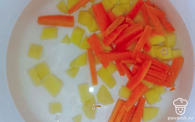 В кастрюлю налить воду, отправить туда картофель и морковь. Поставить на огонь, после закипания варить 10 минут.