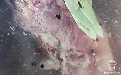 Говядину на кости поместить в кастрюлю. Добавить лавровый лист, соль и черный перец горшком. Поставить на огонь, после закипания убавить огонь до среднего и варить мясо около часа.