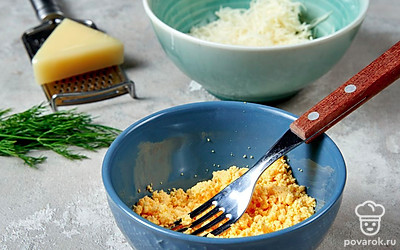 Сделайте начинку. Сваренные яйца почистите, разрежьте на половинки и выньте желтки, поместите их в отдельную миску. Натрите на мелкой терке сыр. К желткам добавьте соль, майонез и тертый сыр, разомните все вилкой до однородной массы.