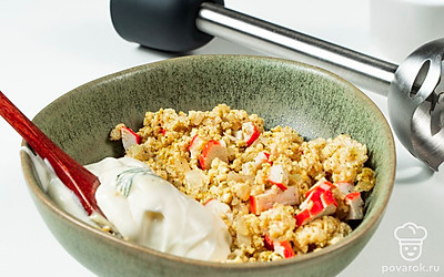 Сделайте начинку. Лук обжарьте в оливковом масле до золотистого цвета 2-3 минуты. Выложите в тарелку желтки, лук, вымоченный мякиш. Измельчите блендером в однородную смесь. Добавьте плавленый сыр, крабовые палочки, перец, соль, хмели-сунели. Тщательно перемешайте.