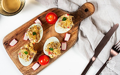 Подавайте фаршированные яйца, запеченные в духовке, на широком красивом блюде.