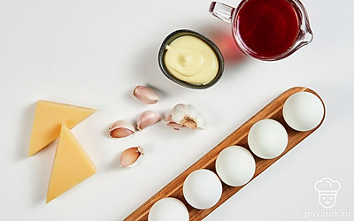 Подготовьте продукты для яичной закуски. Заварите чай, чтобы он получился крепким. Сыр натрите на средней терке. Чеснок почистите, пропустите через пресс.