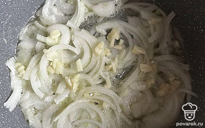 Берем кастрюлю с толстым дном. Нарезаем лук и обжариваем в ней с зубчиком чеснока на оливковом и сливочном масле 2 минуты.