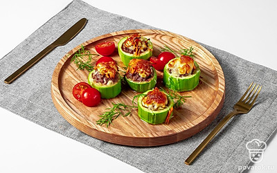 Готовые кабачки переложите на блюдо, украшенное салатом айсберг. Вокруг по желанию выложите несколько помидоров черри.