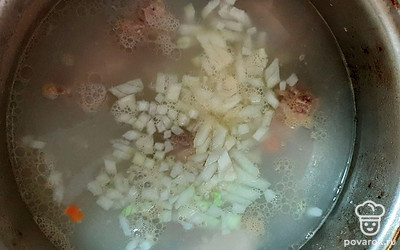 Когда мясо сварилось, добавляем в бульон лук и морковь.