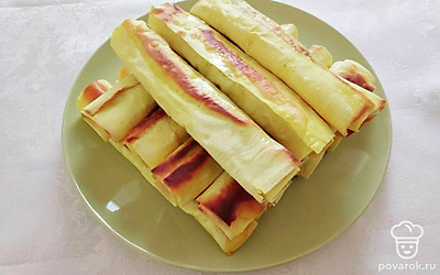 Подавайте жареный лаваш с колбасно-яичной начинкой на большом блюде, рядом выложите свежие овощи и зелень на свой вкус.