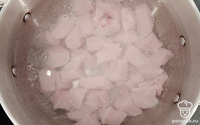 Филе индейки нарежьте небольшими кубиками и выложите в кастрюлю. Залейте филе индейки водой и варите на среднем огне 15 минут.