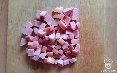 Сосиски нарезаем кубиками, добавляем в кастрюлю.