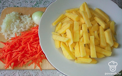 Натрите морковь на терке. Репчатый лук накрошите небольшими кубиками. Картошку очистите, нарежьте брусочками и промойте под холодной водой. 