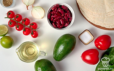 Авокадо, лайм, овощи и зелень тщательно вымойте и просушите. Лук и чеснок очистите от шелухи. Консервированную фасоль переложите в отдельную емкость, лишнюю жидкость слейте. Также подготовьте две сковороды для жарки.