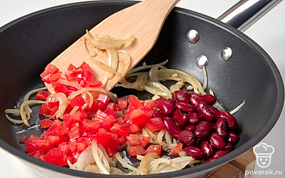 Начните приготовление. В сковороду влейте 2 ст. л. масла и поместите ее на средний огонь. Пока масло раскаляется, подготовьте овощи. Лук нарежьте тонкими полукольцами, а помидоры кубиками. Далее выложите на сковороду лук, обжарьте его 5 минут. После этого добавьте в сковороду помидоры, орегано и соль. Тушите смесь еще 5 минут. Когда содержимое сковороды будет готово, добавьте к нему консервированную фасоль, перемешайте и оставьте на огне еще на 3 минуты. Готовую начинку снимите с огня и дайте остыть.