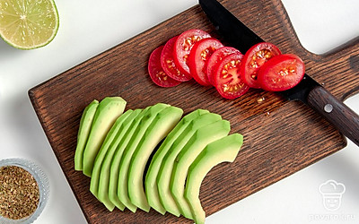 Подготовьте ингредиенты. Авокадо разрежьте на две части, косточку извлеките, а мякоть аккуратно достаньте из кожуры. После этого нарежьте фрукт тонкими ломтиками. Помидоры черри нарежьте кружочкам. Лайм разрежьте пополам и выжмите из него сок. На сковороду налейте небольшое количество масла, поместите на огонь и дождитесь разогревания. Далее выложите на сковороду тортильи и обжарьте их в течение 10 секунд с обеих сторон.