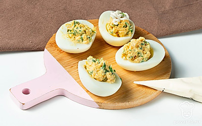 Приготовьте вкусные фаршированные яйца с майонезом. Желтки мелко покрошите, смешайте с горчицей и сметаной в однородную массу. Посолите, поперчите, добавьте зеленый лук. Перемешайте. Начинку разложите по яичным белкам с горкой. Сверху из майонеза сделайте завитки.