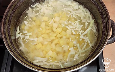 Готовый бульон процедить через ситечко, предварительно убрав вареное мясо. В чистый бульон положить картошку и капусту. Включить огонь, варить на среднем огне.