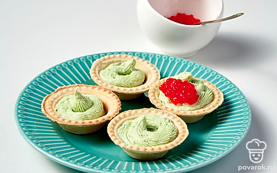 Приготовьте тарталетки. В тарталетки выложите готовую начинку и сделайте в ней небольшое углубление. В него аккуратно чайной ложкой выложите красную икру.