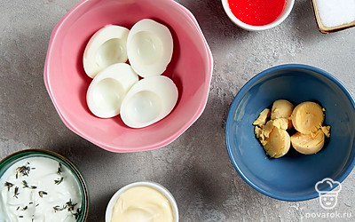 Отварите яйца. Положите яйца в кастрюлю и залейте водой. Поставьте на сильный огонь и варите после закипания 8 минут. Остудите яйца в холодной воде и очистите от скорлупы. Разрежьте яйца пополам и извлеките желток.