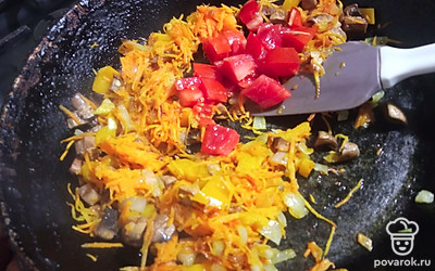 Помидор нарежьте кубиком и добавьте в сковороду. Тушите еще 2-3 минуты.