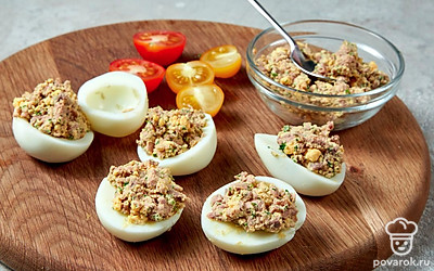 Приготовьте блюдо. Перемешайте ингредиенты в миске, разделите содержимое на 6 равных частей. В каждую половинку яиц разместите начинку.