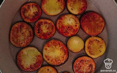 Баклажан порежьте на кружочки толщиной около 2 сантиметров. На среднем огне разогрейте сковороду с добавлением растительного масла. Обжаривайте баклажаны с двух сторон до золотистого цвета. Готовые баклажаны выкладывайте на блюде в один слой.