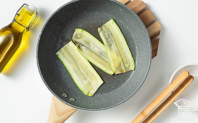 Приготовьте кабачки. Разогрейте сковороду с добавлением масла и на среднем огне обжарьте кабачки. Для обжарки с одной стороны потребуется примерно 1 минута.