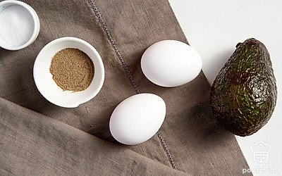 Авокадо тщательно промойте, после чего аккуратно разрежьте на две части и, слегка скручивая, разделите. Косточку удалите. Куриные яйца и зелень для подачи вымойте, просушите. Также подготовьте форму для запекания.