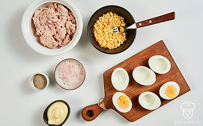 Сварите яйца. Яйца, залитые холодной водой, доведите до кипения. Варите не больше 10 минут. Охладите, снимите скорлупу. Разрежьте пополам. Желток извлеките, разомните вилкой в однородную массу. Ножом или маленькой ложкой аккуратно снимите изнутри часть белка, чтобы освободить побольше места для начинки.