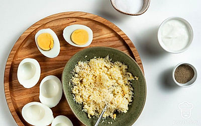 Сделайте начинку. Яйца разрежьте пополам, извлеките желтки и разомните их вилкой. Сыр натрите на мелкой терке. Мелко нарежьте чеснок. Смешайте желтки, сыр, чеснок, укроп и майонез.