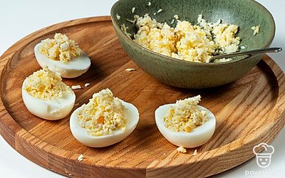 Нафаршируйте яйца. Посолите и поперчите начинку по вкусу. Хорошо размешайте полученную массу до однородного состояния. Приготовленной смесью нафаршируйте половинки белков.