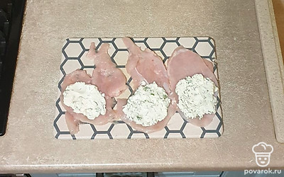 На каждый кусочек мяса выложите начинку из творожного сыра, сверните в рулетики.