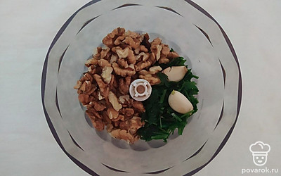 В чашу блендера выложите измельченную петрушку, орехи и чеснок. Хорошо измельчите, пока смесь не станет однородной. Для этого потребуется около 5-7 минут. Готовую смесь переложите в глубокую чашу.