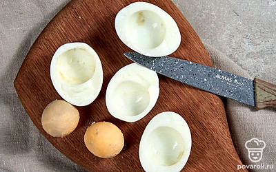 Отварите яйца. Выложите яйца в кастрюлю и налейте воды. Поставьте на сильный огонь и после закипания варите 8-10 минут. Остудите в холодной воде. Очистите от скорлупы и разрежьте пополам каждое яйцо. Отделите белки от желтков.