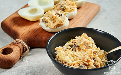 Нафаршируйте яйца. Наполните белки начинкой, используя чайную ложку. Сделайте красивую «шапочку».