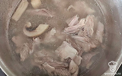 Через 1 час свинину достаньте, отделите мясо от костей. В бульон выложите грибы и мясо.