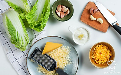 Приготовьте начинку. Смешайте майонез и пропущенный через пресс чеснок. Разомните желтки вилкой, добавьте к ним тертый сыр и немного соуса для вязкости.