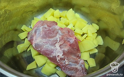 Картошку очистите и нарежьте. Выложите в кастрюлю картошку и свиные ребрышки. Залейте водой и поставьте на средний огонь. Варите 30 минут. 